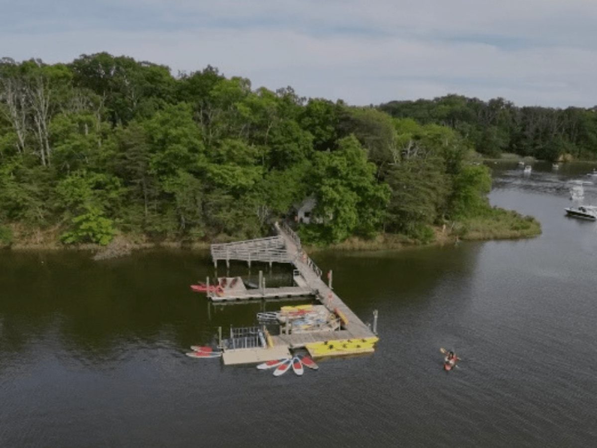 a boat floating along a river next to a body of water