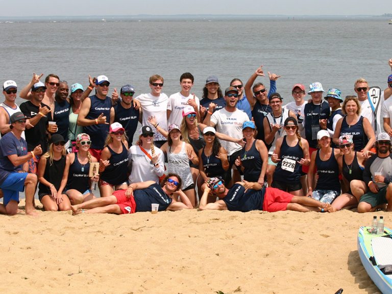 a group of people on a beach posing for the camera