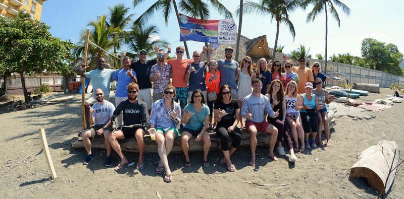 a group of people on a beach posing for the camera