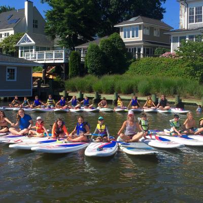 a group of people riding on the back of a boat in the water
