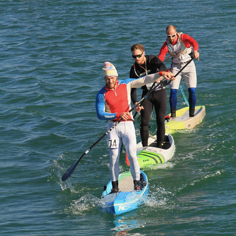 a group of people riding skis on a body of water
