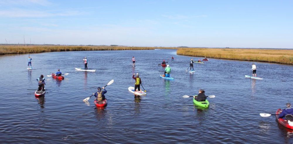 a group of people riding on the back of a boat in the water
