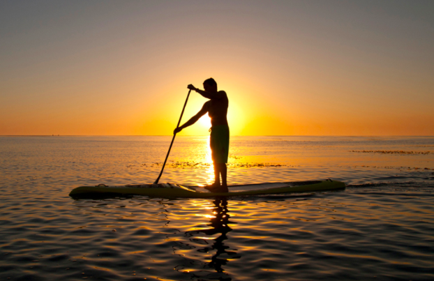 a man on a paddle board in a body of water