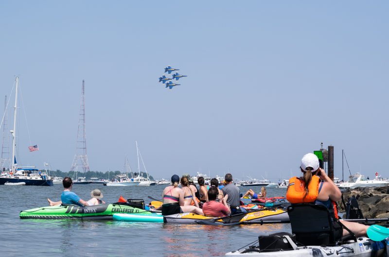 People on kayaks and paddle boards watching United States Navy "Blue Angels" jet planes air show