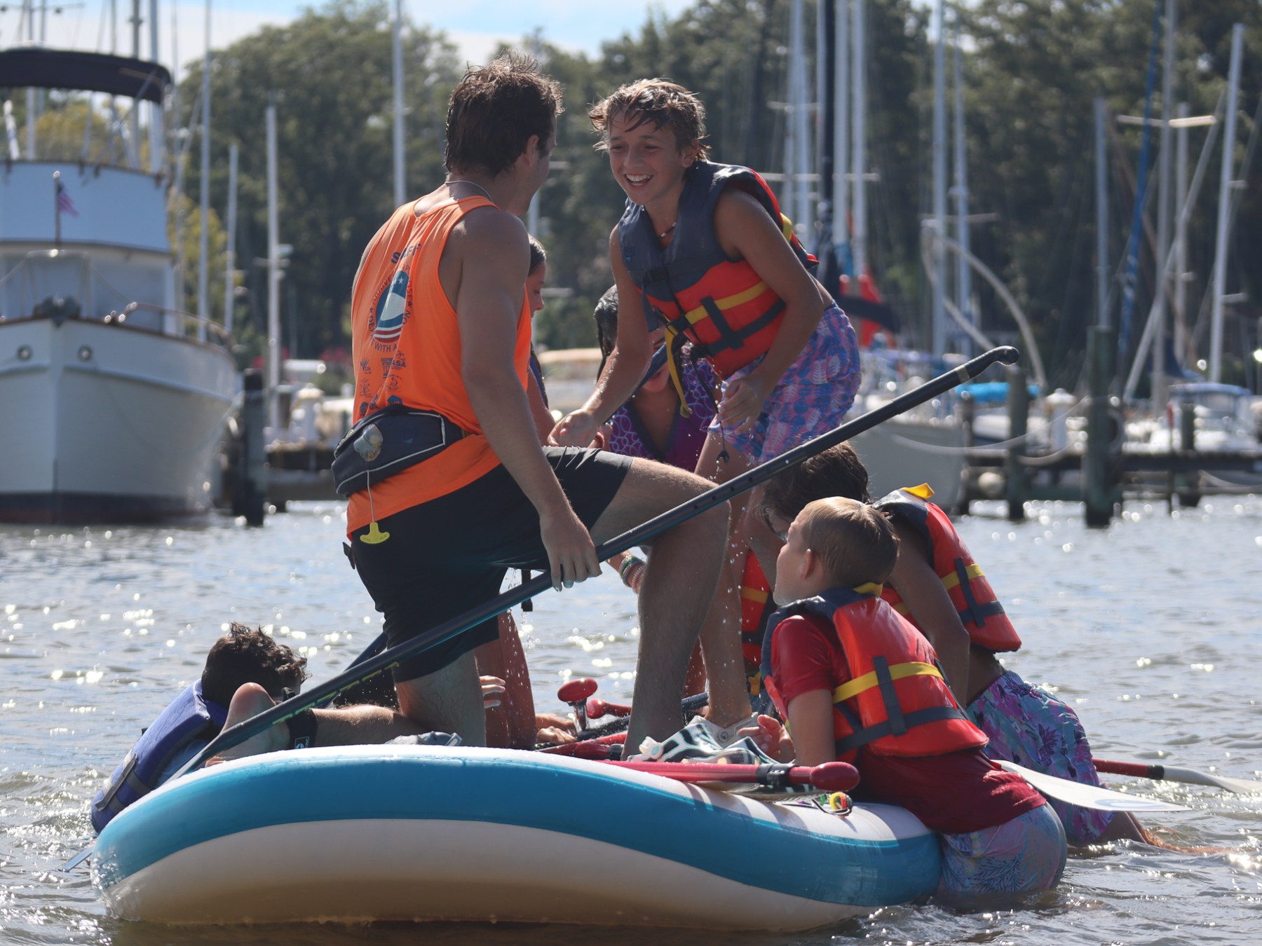 a group of people on a giant paddleboard or our party barge