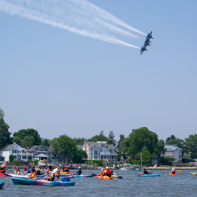 a group of people flying kites on a boat in the water