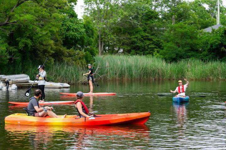 a group of people riding on the back of a boat in the water