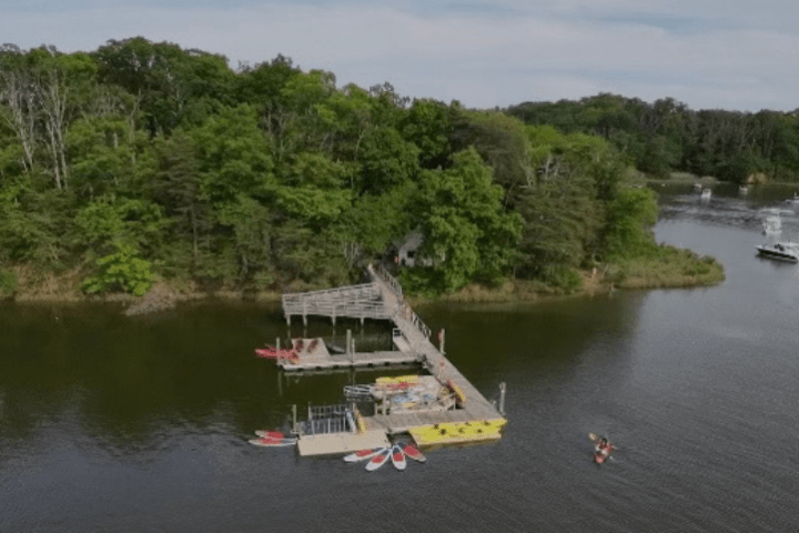 a boat floating along a river next to a body of water