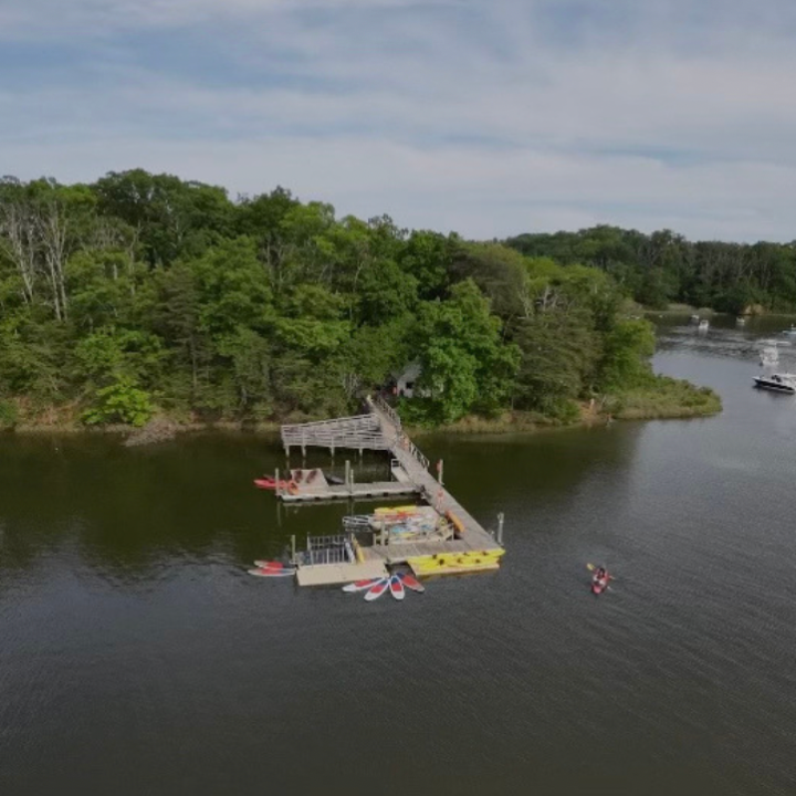 a boat floating along a river next to a body of water