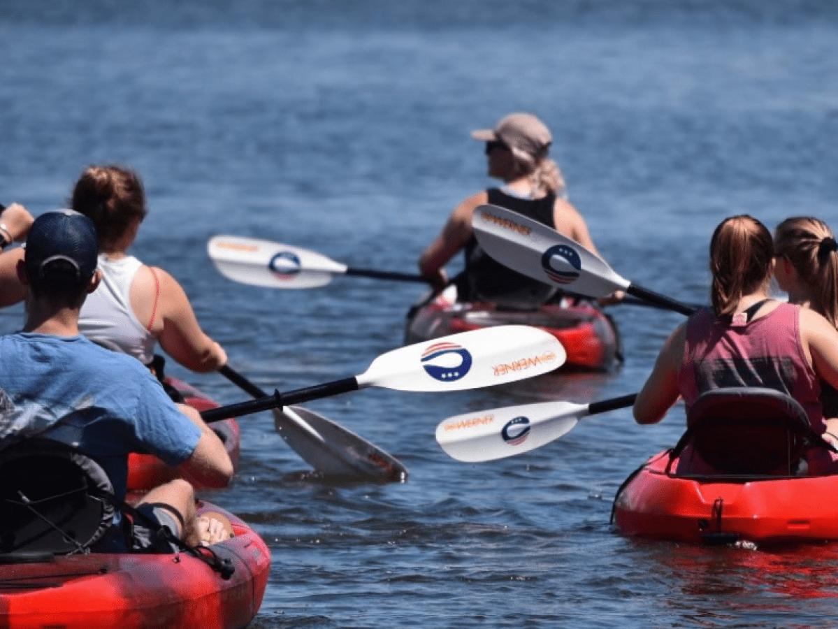 a group of people rowing a boat in the water