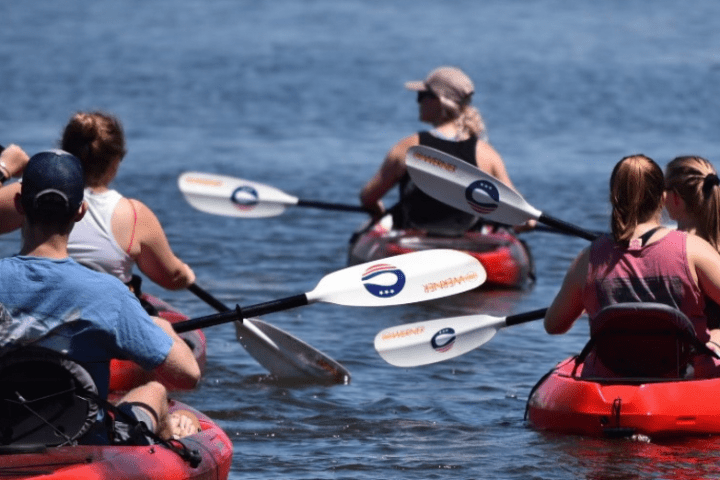 a group of people rowing a boat in the water