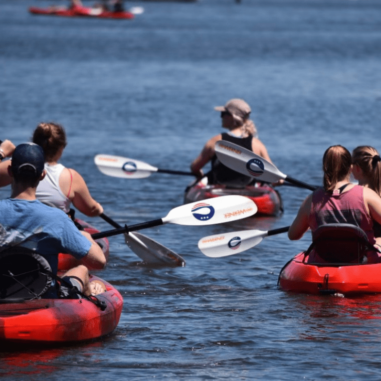 a group of people rowing a boat in the water