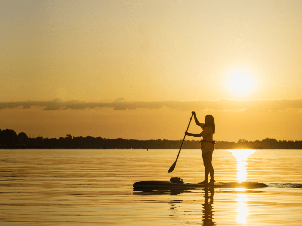 a man riding on the back of a boat in the water