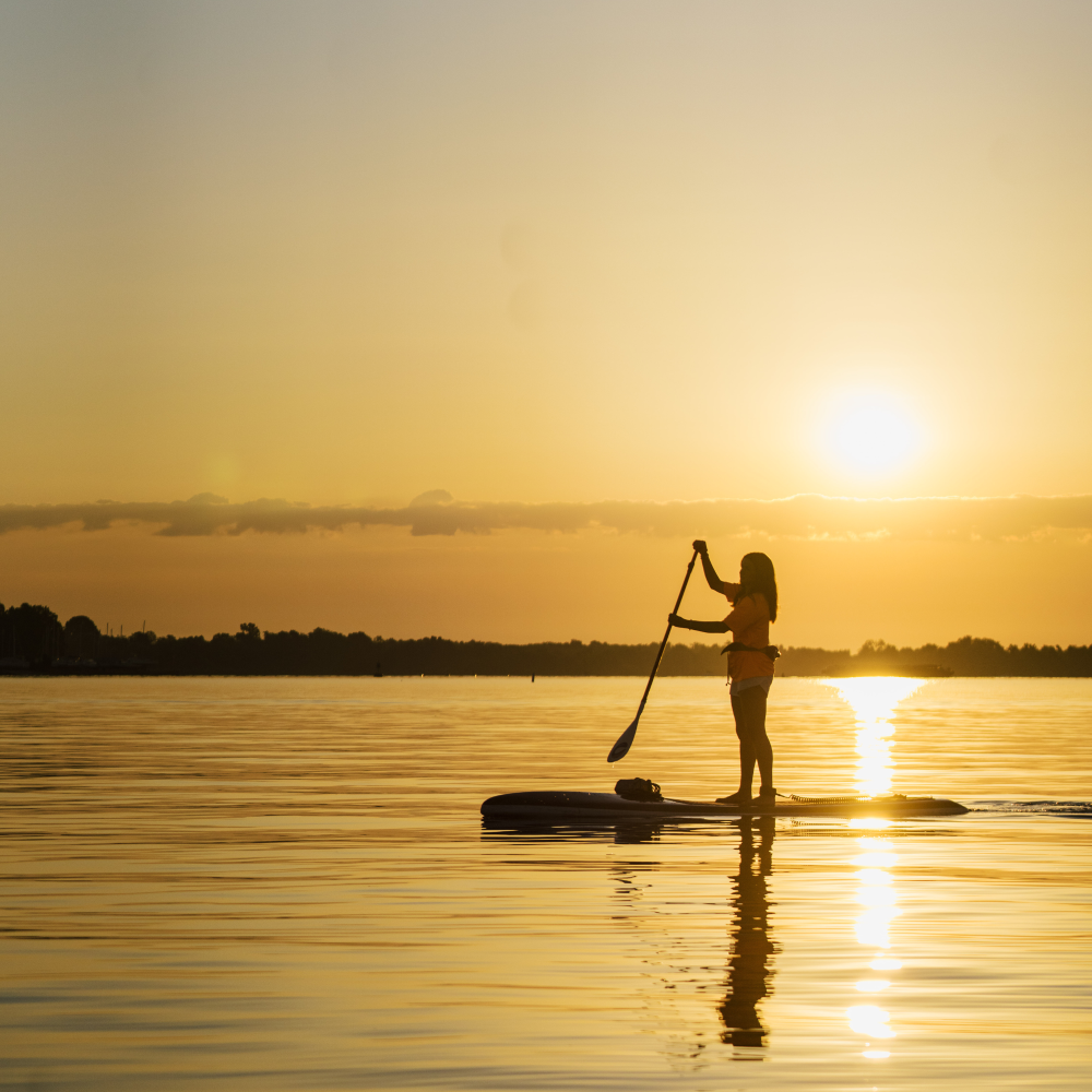 a man riding on the back of a boat in the water