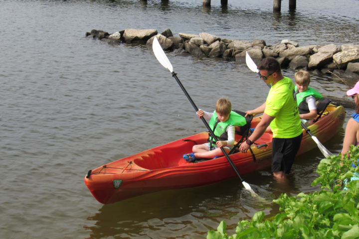 a group of people in a small boat in a body of water