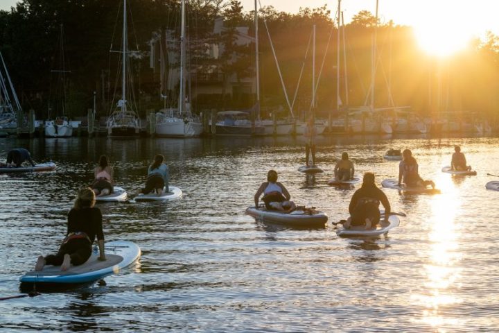 a group of people riding on the back of a boat in the water