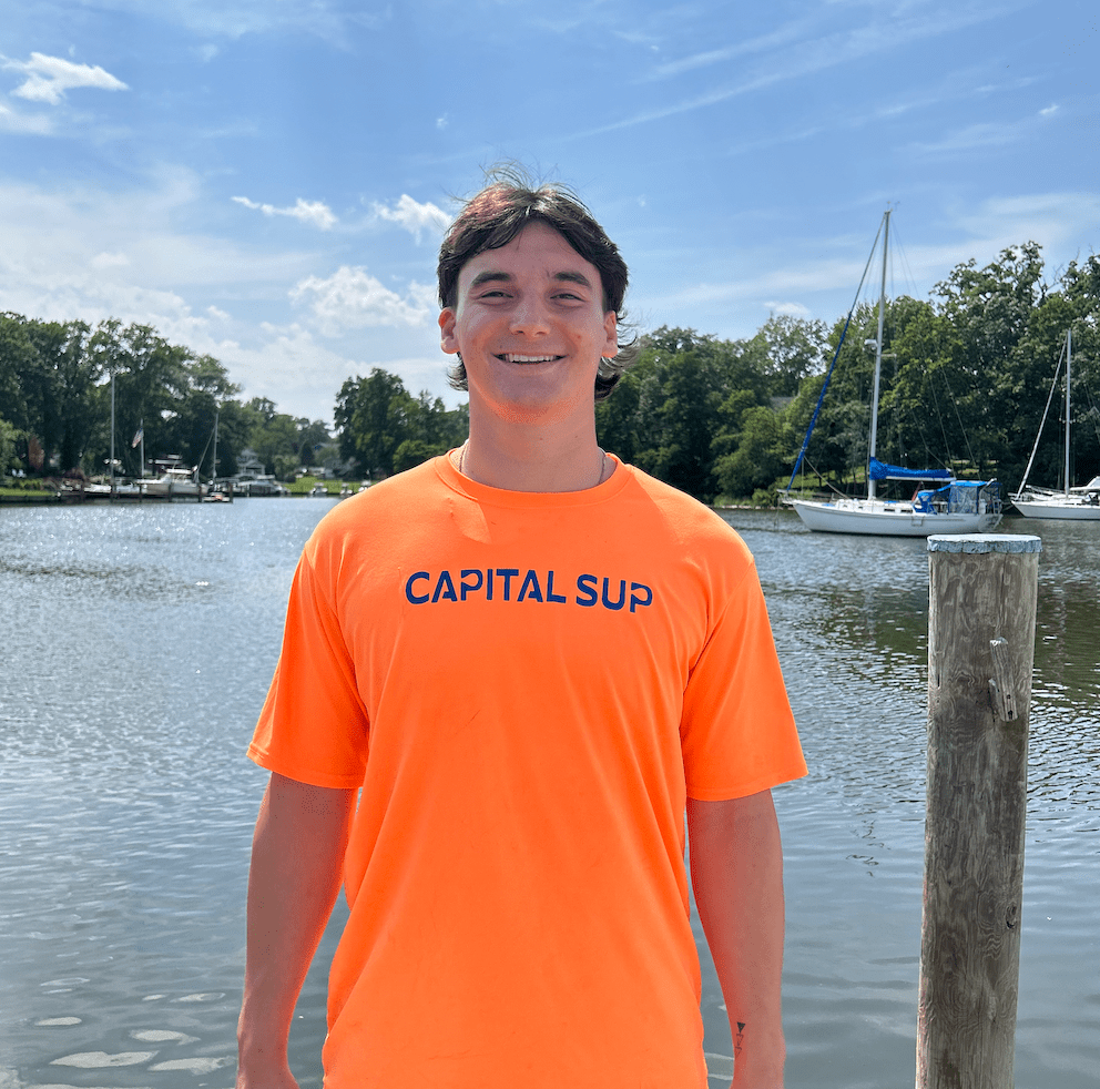 a man standing in front of a body of water